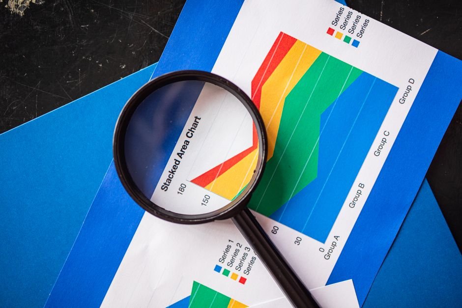 Magnifying glass over data analysis charts, symbolising root-cause diagnosis with Oracle AWR and ASH