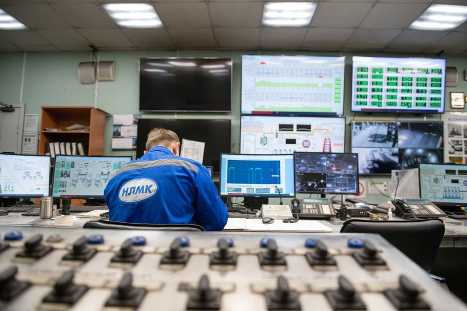 Engineer monitoring Oracle RAC cluster health on multiple screens