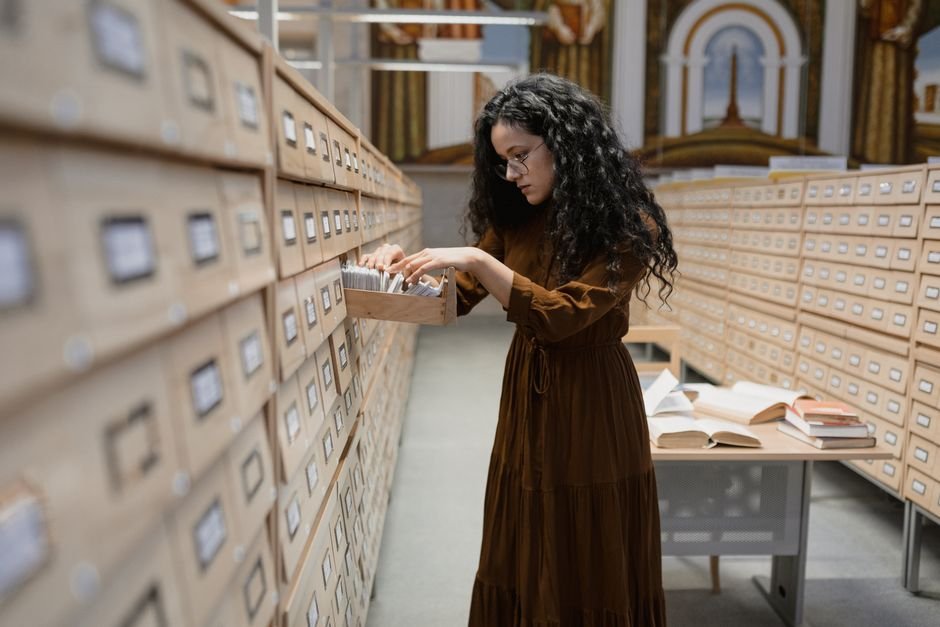 Woman searching a library card catalog - the retrieval step of RAG explained with a physical analogy