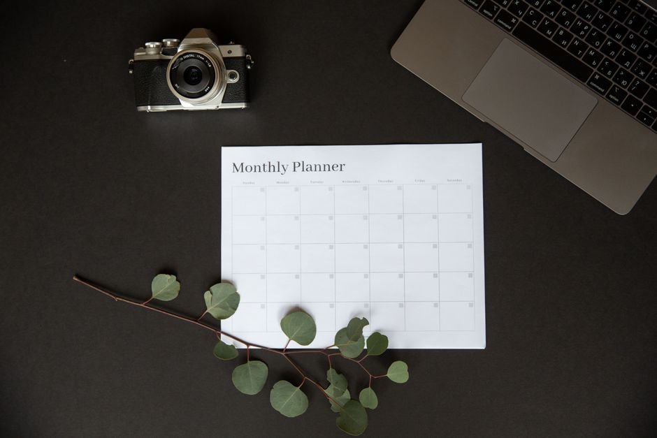 Monthly planner on a desk representing DBMS_SCHEDULER calendar syntax for Oracle job schedules